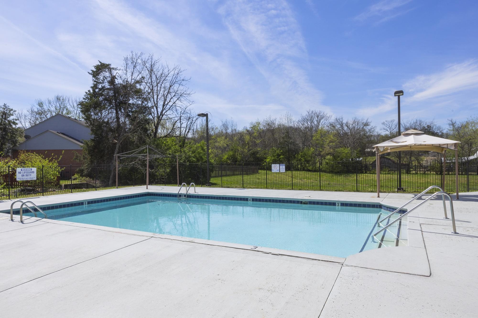 513 Cold Stream Place Nashville, TN 37221 - Photo 40 of 40 a view of a swimming pool with a table and chairs under an umbrella