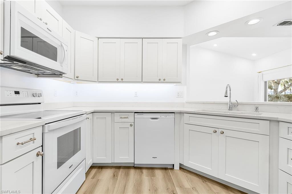 661 Windsor Square, Unit 101 Naples, FL 34104 - Photo 11 of 40 a kitchen with white cabinets and sink