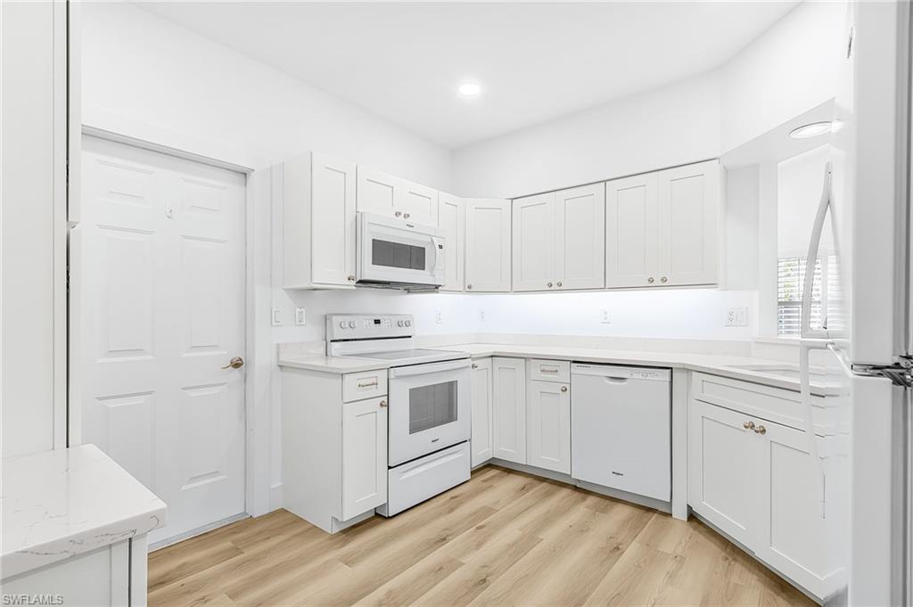 661 Windsor Square, Unit 101 Naples, FL 34104 - Photo 12 of 40 a kitchen with white cabinets stainless steel appliances and sink