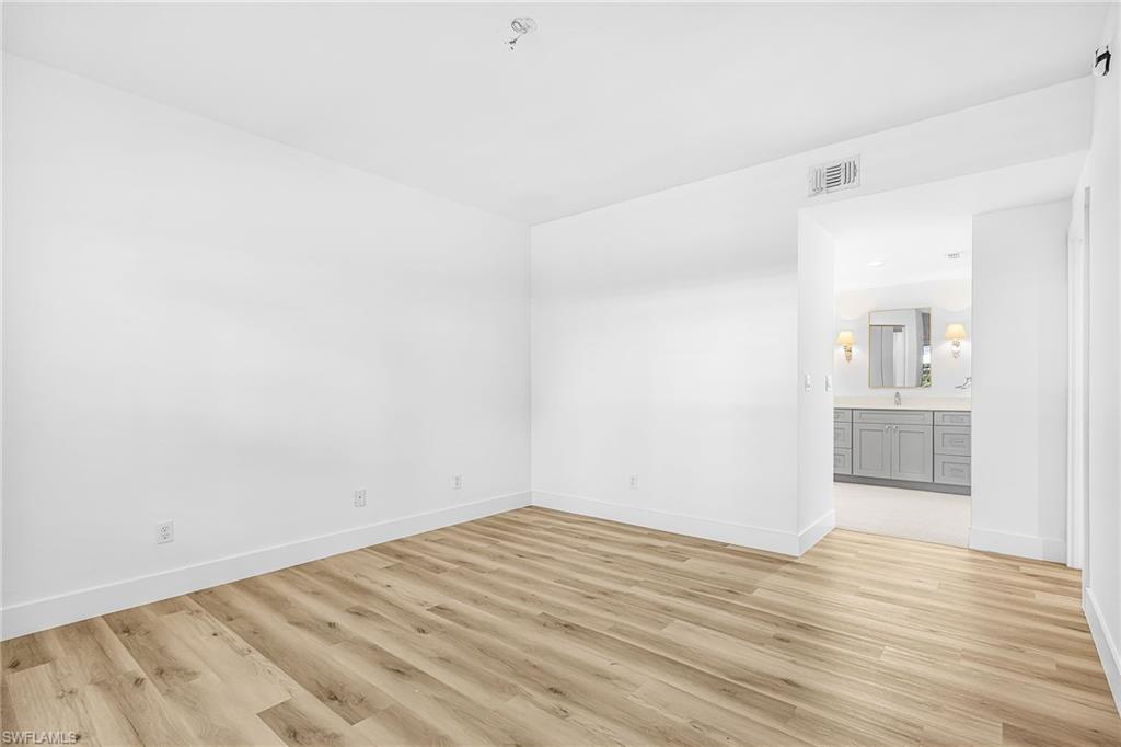 661 Windsor Square, Unit 101 Naples, FL 34104 - Photo 18 of 40 a view of empty room with wooden floor