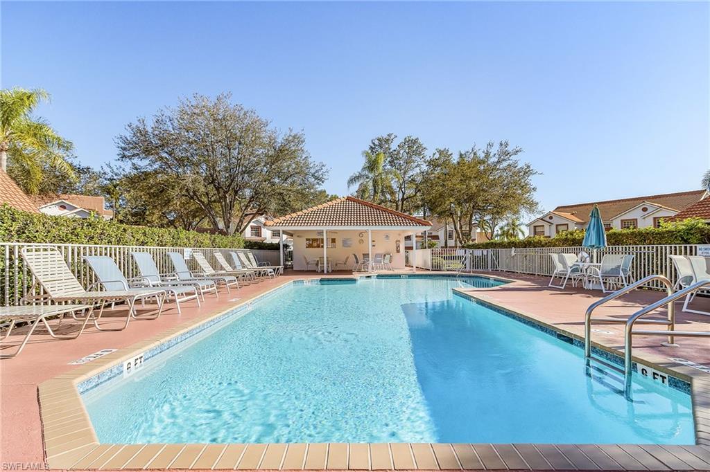 661 Windsor Square, Unit 101 Naples, FL 34104 - Photo 31 of 40 a view of a swimming pool with a lounge chair
