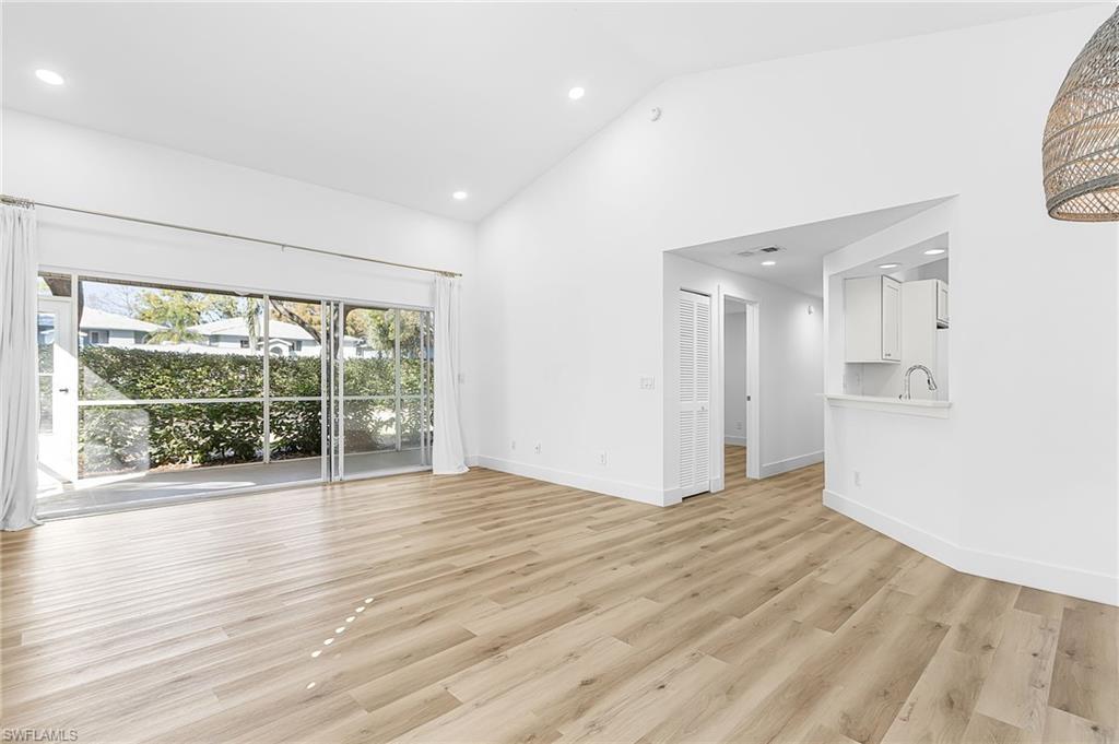 661 Windsor Square, Unit 101 Naples, FL 34104 - Photo 5 of 40 a view of an empty room with wooden floor and a window