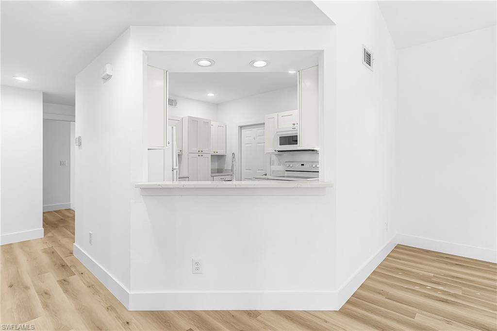 661 Windsor Square, Unit 101 Naples, FL 34104 - Photo 9 of 40 a view of kitchen and hall with wooden floor