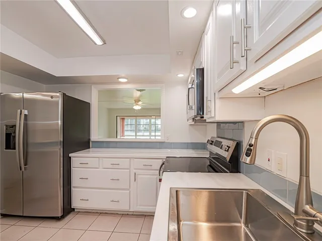 a kitchen with cabinets a sink and stainless steel appliances