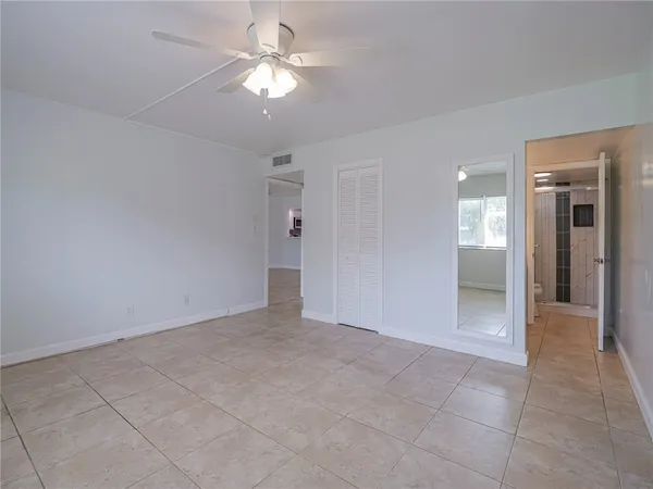 an empty room with fan and entrance