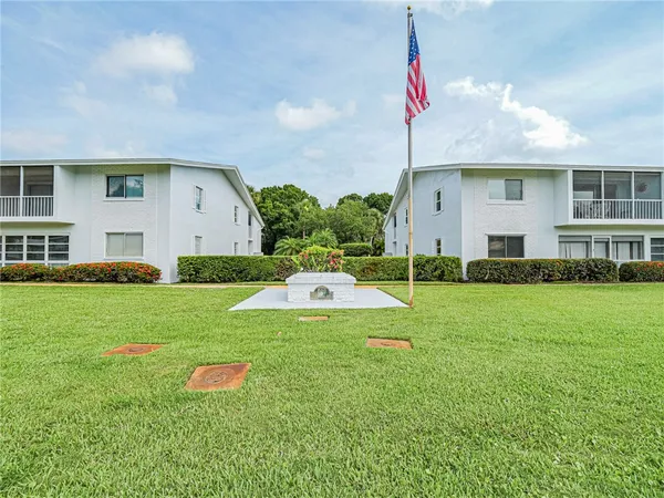a view of a house with backyard and sitting area