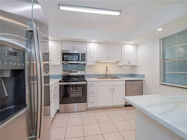 a kitchen with granite countertop a stove sink and refrigerator