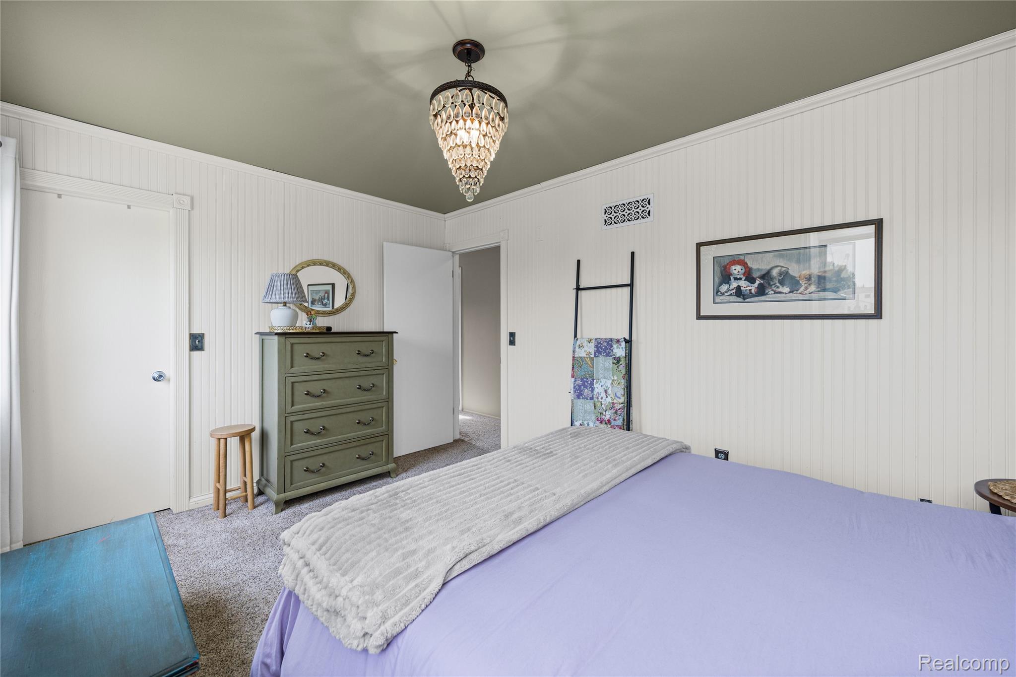 3553 Loon Lake Road Wixom, MI 48393 - Photo 12 of 25 Interior room featuring a chandelier light fixture, vertical paneled wall detailing, a contrasting painted ceiling, and carpet flooring
