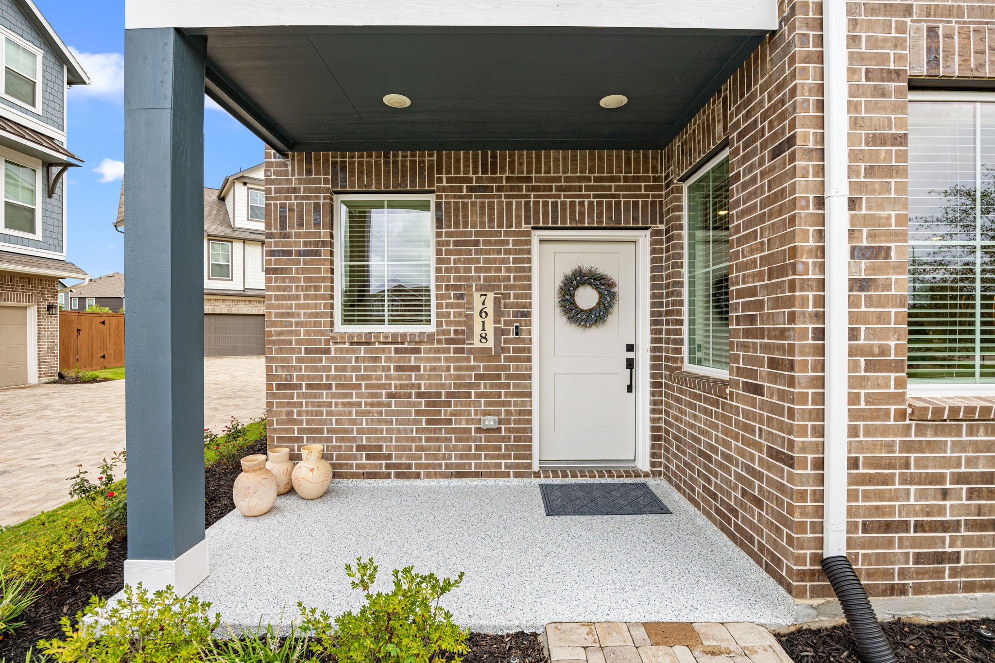 7618 Redbud Orchard Road Katy, TX 77493 - Photo 3 of 26 Your front porch boasts an epoxy caoting for easy maintenance and maximum comfort.You will find the same coating in the garage, also color-coordinated with the home's exterior color scheme. This is the perfect spot for your bistro table or rocking chairs. The covered area and Ring doorbell provide a safe and secure spot for package deliveries, even in inclement weather.
