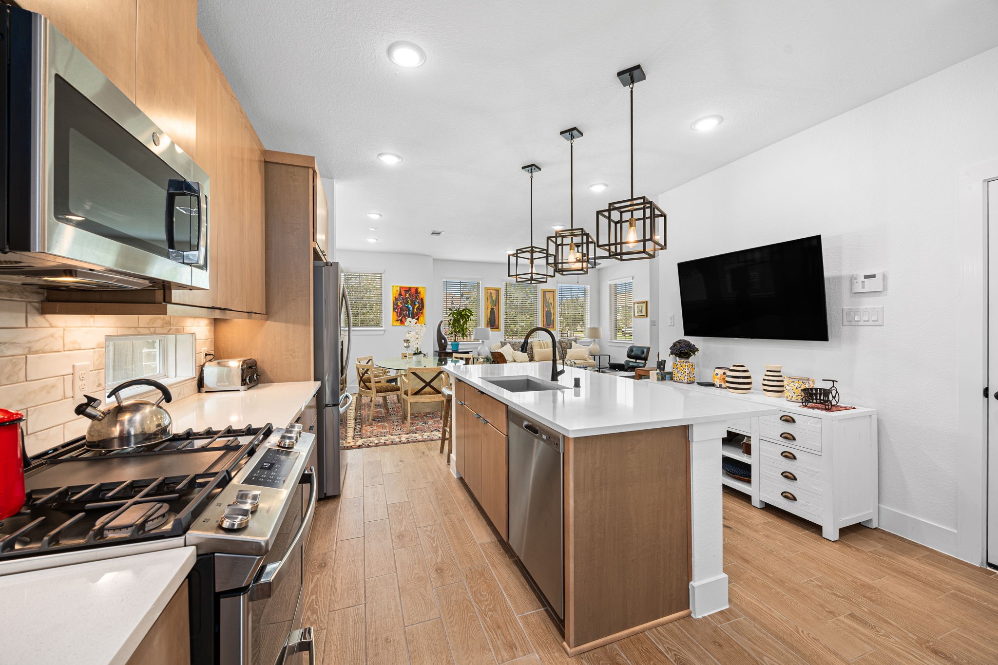 7618 Redbud Orchard Road Katy, TX 77493 - Photo 8 of 26 Quartz countertops, upgraded pendant lighting, and the perfect balance of warm and cool tones set the kitchen apart. The gas range with griddle is waiting for the chef of the household to take charge.