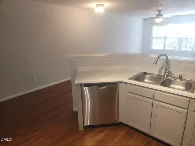 a kitchen with a sink cabinets and wooden floor