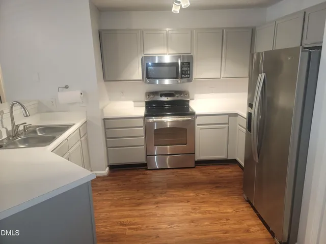a kitchen with a sink and a refrigerator