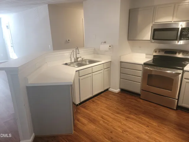 a kitchen with a sink cabinets and stainless steel appliances