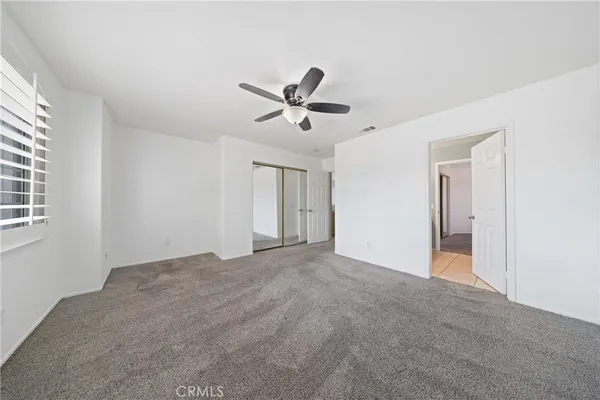 a view of a livingroom with a ceiling fan and window