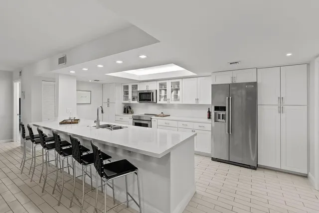 a kitchen with stainless steel appliances a sink a stove a refrigerator and cabinets
