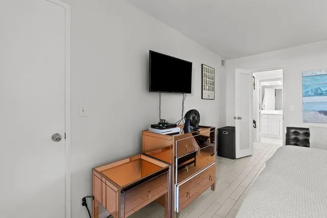 a living room with furniture a flat screen tv and kitchen view