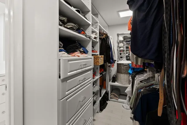 a view of walk in closet with clothes and shoes