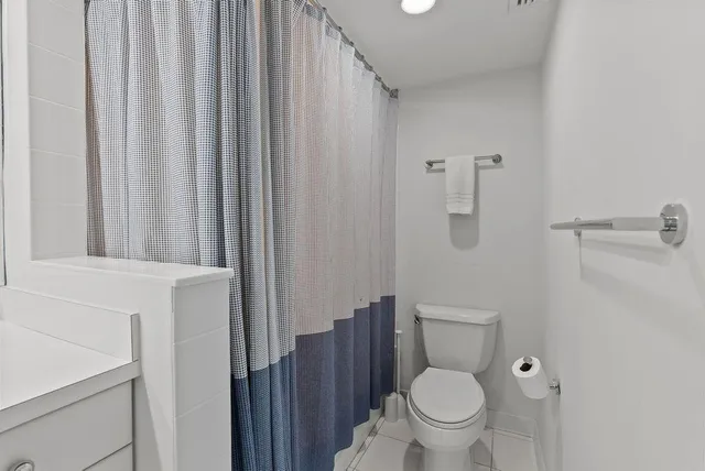 a white toilet sitting next to a shower curtain