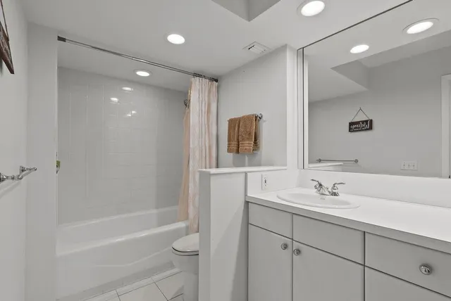 a bathroom with a shower sink vanity and mirror
