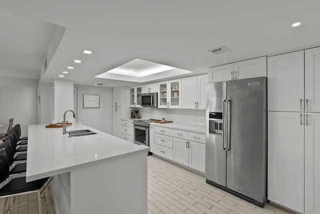 a kitchen with stainless steel appliances a refrigerator sink and stove
