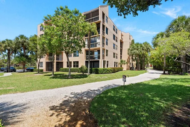 a view of a big building with a big yard and large trees