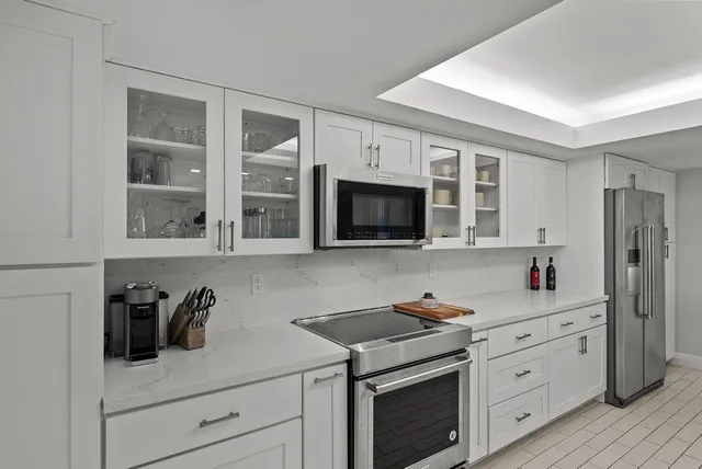 a kitchen with white cabinets and appliances
