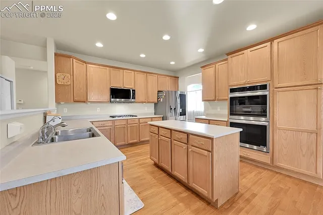 a kitchen with a sink a counter top space stainless steel appliances and cabinets