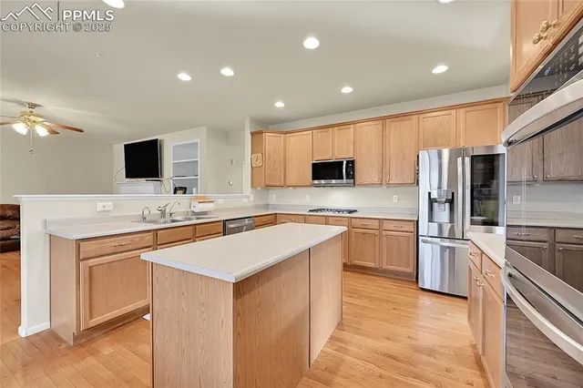 a kitchen with stainless steel appliances granite countertop a sink stove microwave and refrigerator