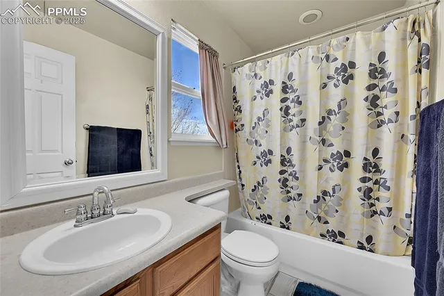 a bathroom with a granite countertop sink a mirror and a shower