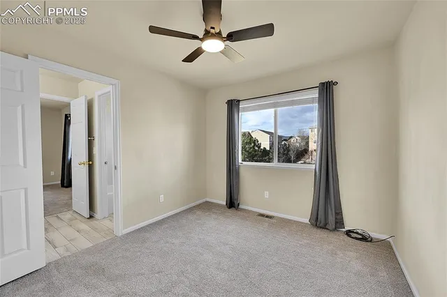 a view of a livingroom with a ceiling fan and window