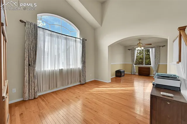 a view of a livingroom with wooden floor and a kitchen