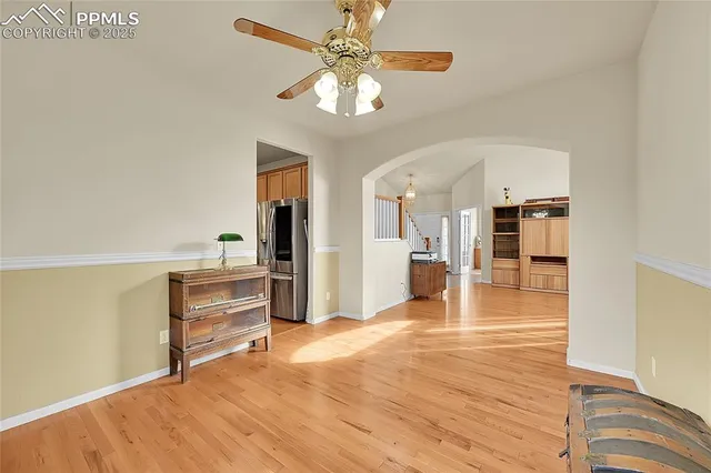 a view of a livingroom with wooden floor and a ceiling fan