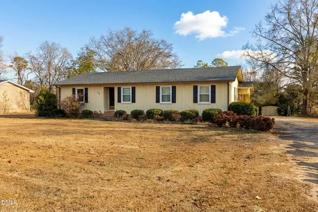 a front view of house with yard and trees around