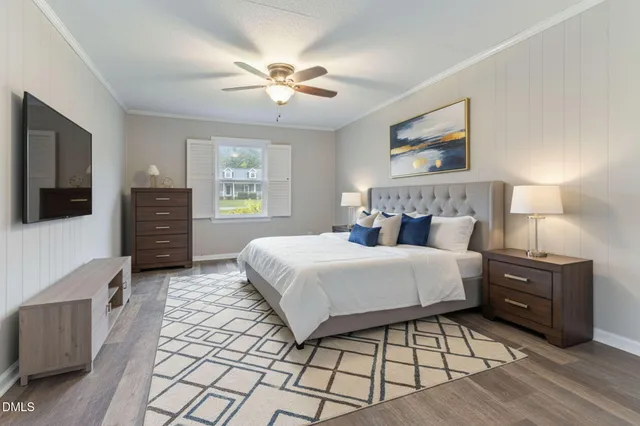 a bedroom with a bed and a flat tv screen on the dresser