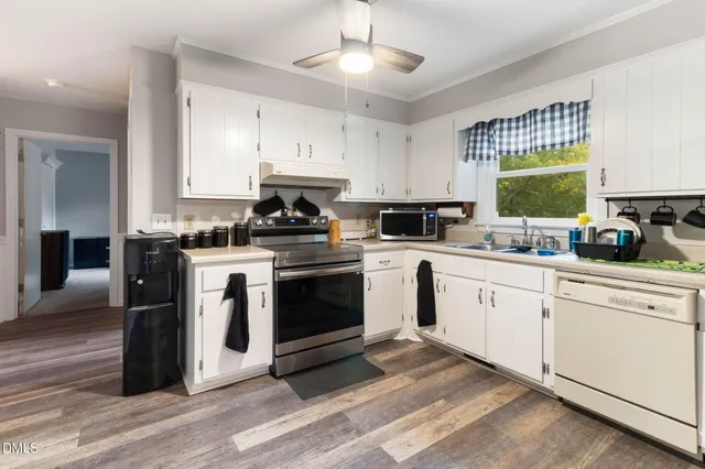 a kitchen with a stove white cabinets and white appliances