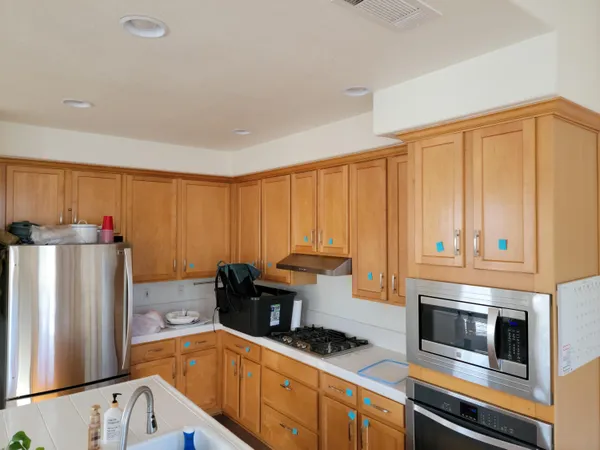 a kitchen with stainless steel appliances a refrigerator a sink a stove and cabinets