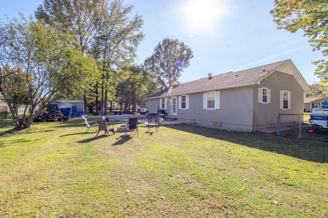 a view of swimming pool with outdoor seating and house in the background