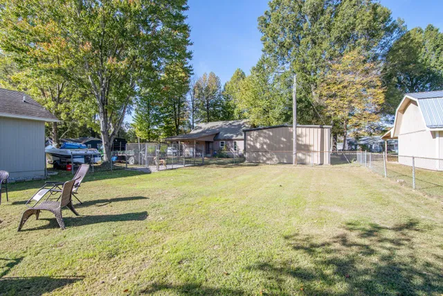 a view of a swimming pool with a bench and trees around