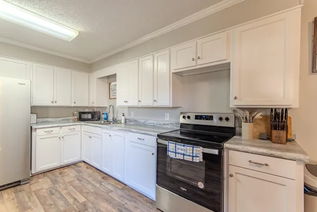 a kitchen with granite countertop white cabinets and appliances