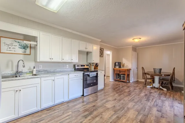 a kitchen with sink cabinets and wooden floor