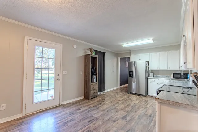 a view of a kitchen with wooden floor and electronic appliances