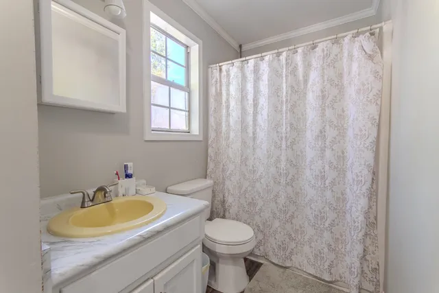 a bathroom with a sink toilet and window
