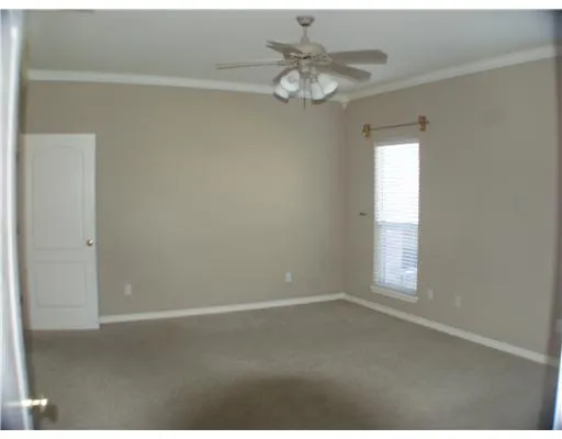 an empty room with windows and chandelier fan