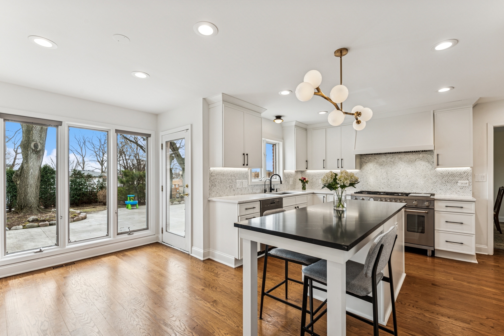 3107 Old Glenview Road Wilmette, IL 60091 - Photo 5 of 29 a kitchen with granite countertop a stove a sink a refrigerator a stove and white cabinets with wooden floor