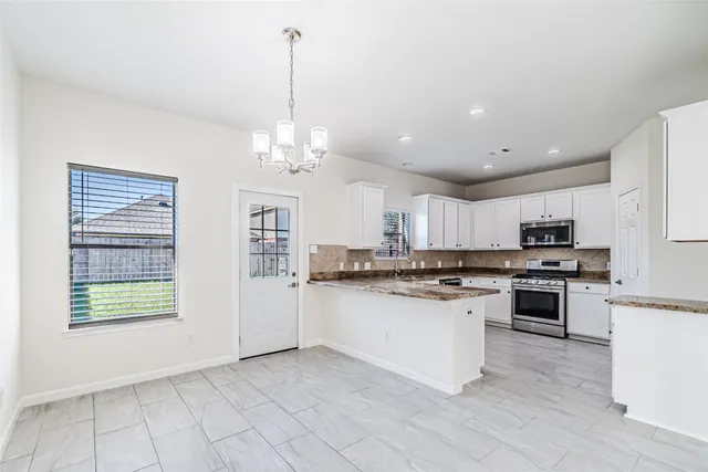 a kitchen with stainless steel appliances granite countertop a stove top oven a sink dishwasher and a refrigerator