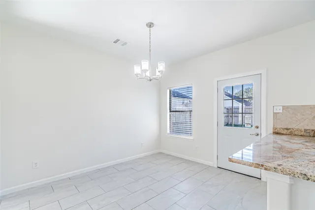 a view of a livingroom with a chandelier fan and kitchen floor