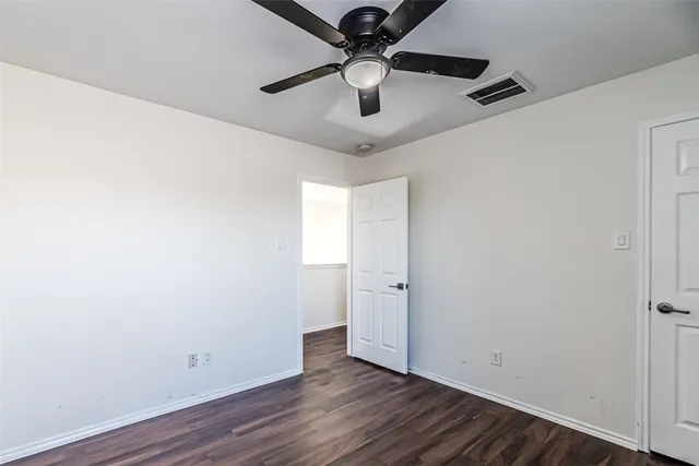 a view of a room with wooden floor and a ceiling fan