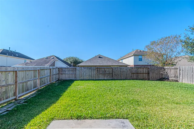 a view of a yard with wooden fence
