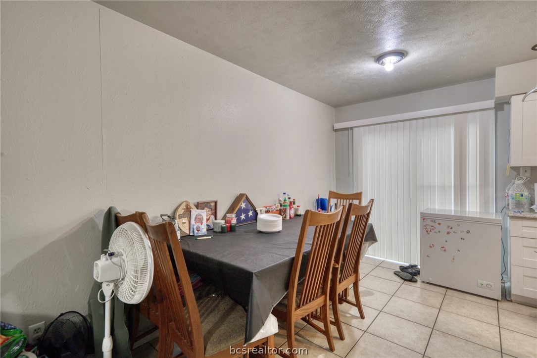 1908 Barak Lane, Unit 14 Bryan, TX 77802 - Photo 5 of 10 Dining area featuring a textured ceiling and light tile patterned floors