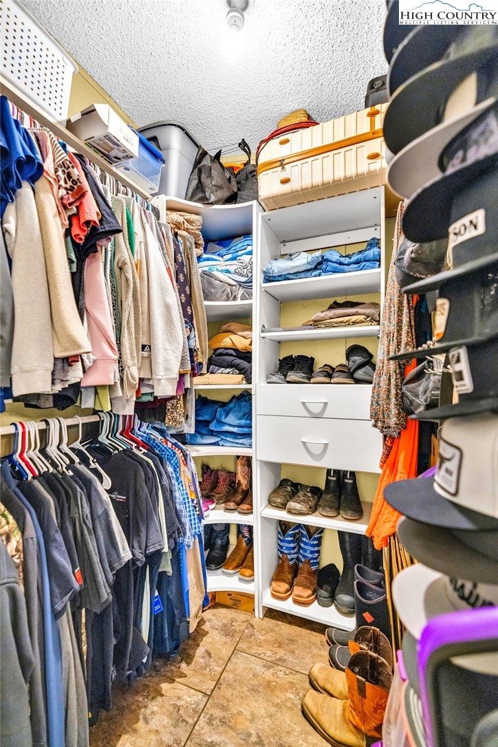 747 Nathans Creek School Road Crumpler, NC 28617 - Photo 22 of 42 a view of walk in closet with clothes and shoes